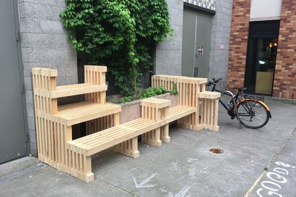 Fresh installation of untreated alley benches, built around existing planters.